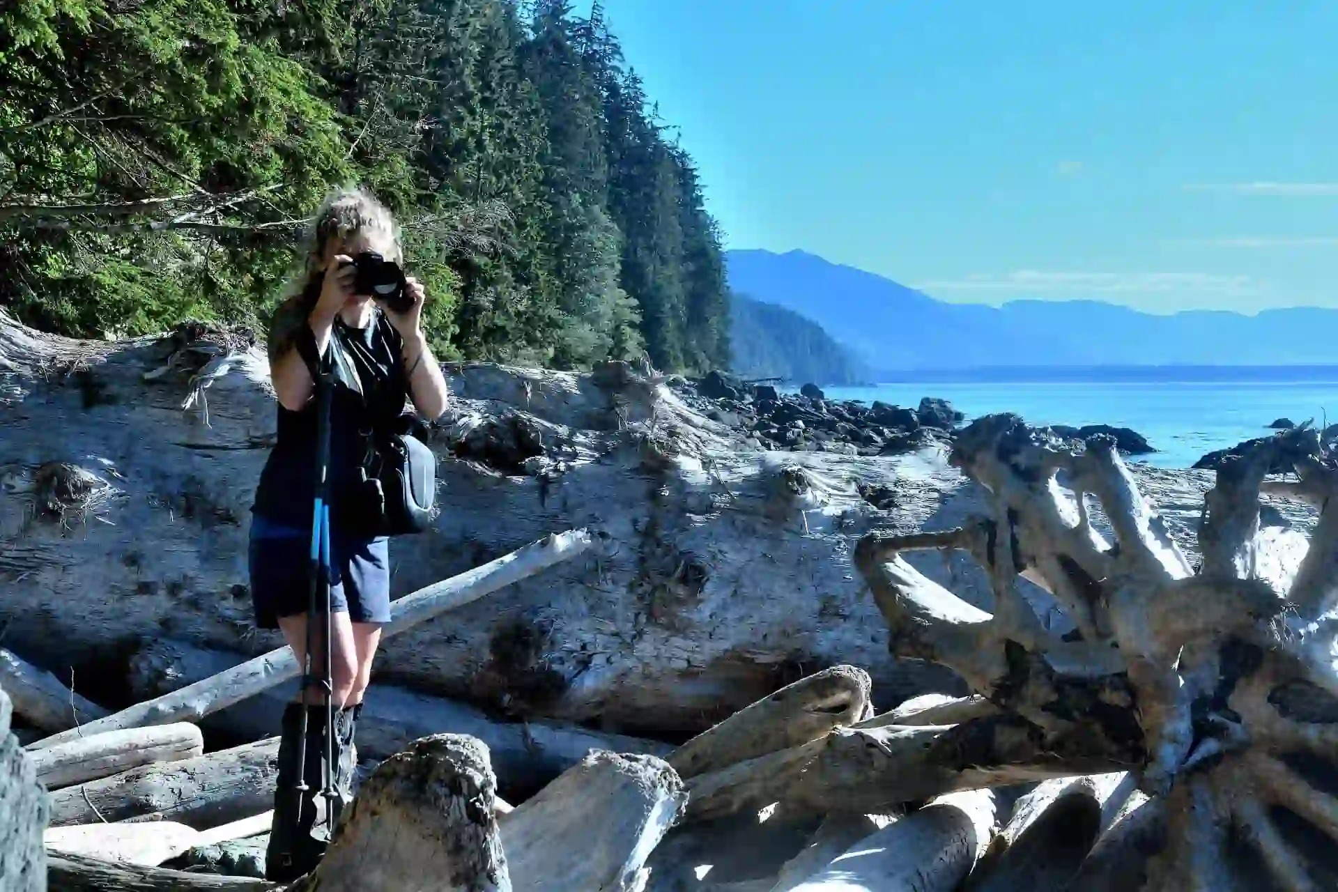 Auf dem West Coast Trail, Vancouver Island in Westkanada, Verena Schmidt steht auf Treibholz und fotografiert